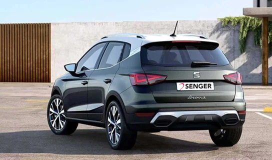 Der SEAT Arona in grau ist von hinten zu sehen und steht vor einer Betonwand