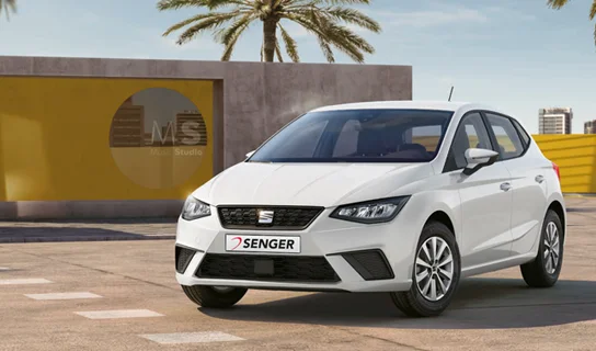 Ein weißer SEAT Ibiza steht vor einer gelb-grauen Betonwand