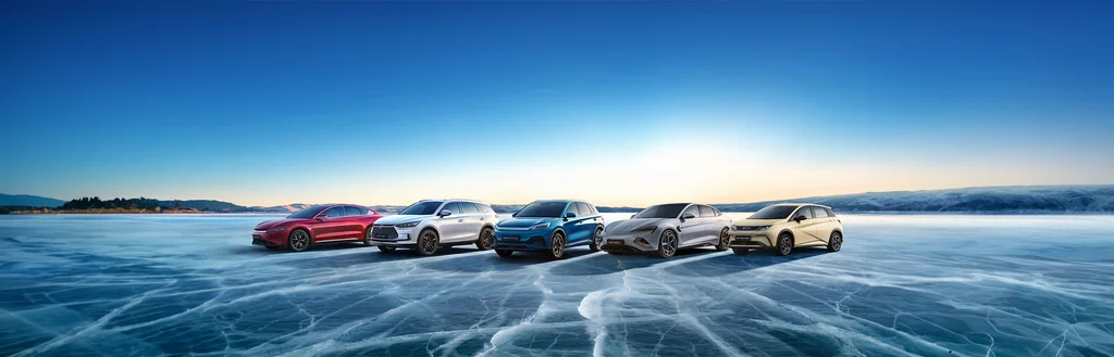 BYD HAN in rot, BYD TANG in weiß, BYD ATTO 3 in blau, BYD SEAL in silber und der BYD DOLPHIN in Eierschalen auf einem Bild mit blauem Untergrund und Himmel.