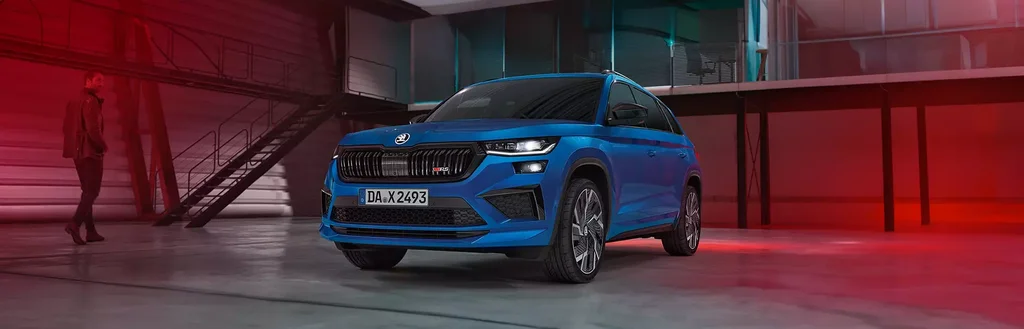Skoda Kodiaq RS in blau parkt in einer leeren Lagerhalle.