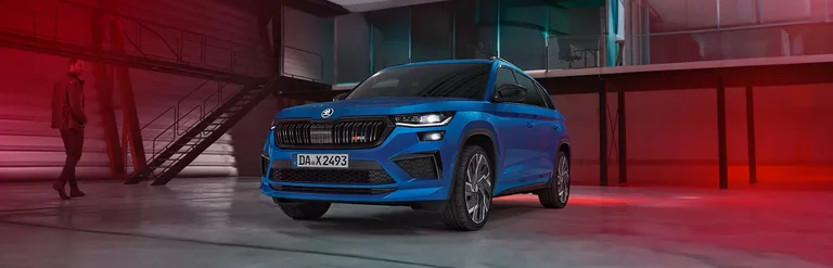 Skoda Kodiaq RS in blau parkt in einer leeren Lagerhalle.